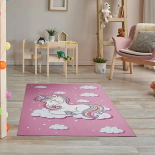 rosa Kinderteppich mit Einhornmotiv liegt auf dem Boden eines Mädchenzimmers. - rosa Kinderteppich mit Einhornmotiv liegt auf dem Boden eines Mädchenzimmers.