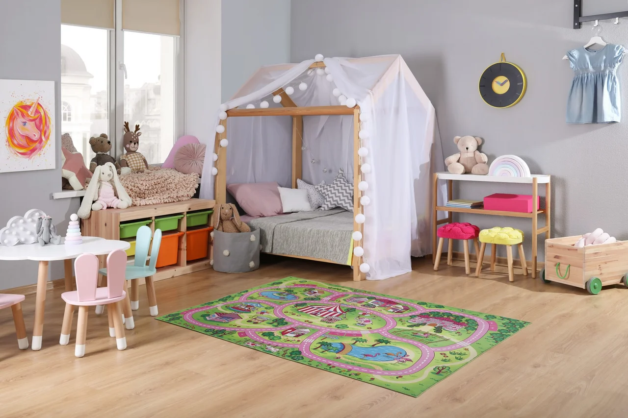 Kinderspielteppich der eine Landschaft mit Straßen zeigt, liegt auf dem Boden in einem Kinderzimmer. - Kinderspielteppich der eine Landschaft mit Straßen zeigt, liegt auf dem Boden in einem Kinderzimmer.